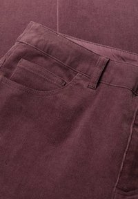Burgundijas krāsas korduroja audums ar smalku vertikālu ribojumu. Iespējamās prasības: aizmugures kabata, jostas cilpas un gluda, pielāgota jostasvieta.