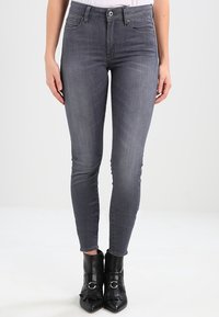 Grå slim fit jeans i denim med en klassisk femficksdesign och en subtil blekt textur. Kombinerade med svarta klackiga ankelstövlar.