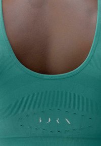 Teal sporttanktop met een ronde halslijn, textuur ribbeling en geperforeerd detail met een zilveren logo in het midden.