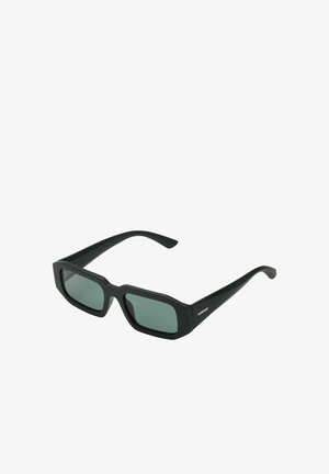 Lunettes de soleil rectangulaires noires avec des verres teintés foncés et des branches droites, vue en angle montrant le logo "KOMONO" sur la branche.