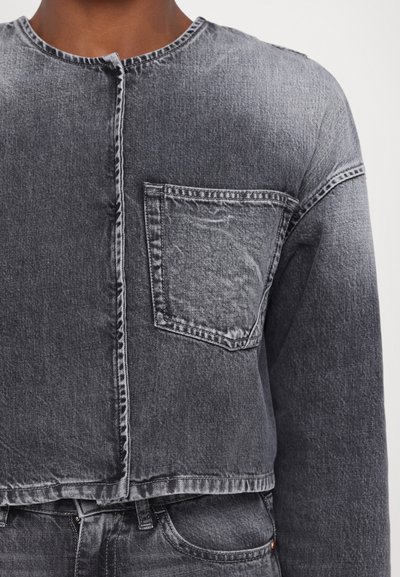 Jachetă din denim gri, cu guler rotund, lungime scurtă, închidere frontală cu nasturi și un singur buzunar pe piept. Material texturat cu un finisaj șters.