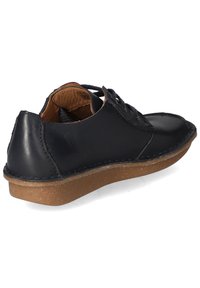 Zapato de cuero negro con interior marrón, diseño de cordones, puntera redonda y suela de goma texturizada. Detalles de costura alrededor de los bordes.