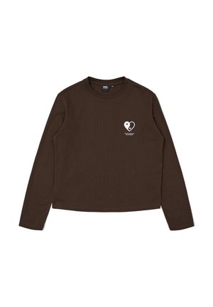 Camiseta de manga larga marrón hecha de algodón, con un gráfico de corazón blanco en el lado izquierdo del pecho y un cuello redondo.