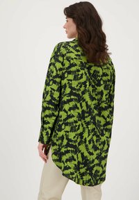 Langmouwhemd met een groen en zwart abstract patroon, lichtgewicht stof, gebogen zoom en met knoopsluiting bij de mouwen.