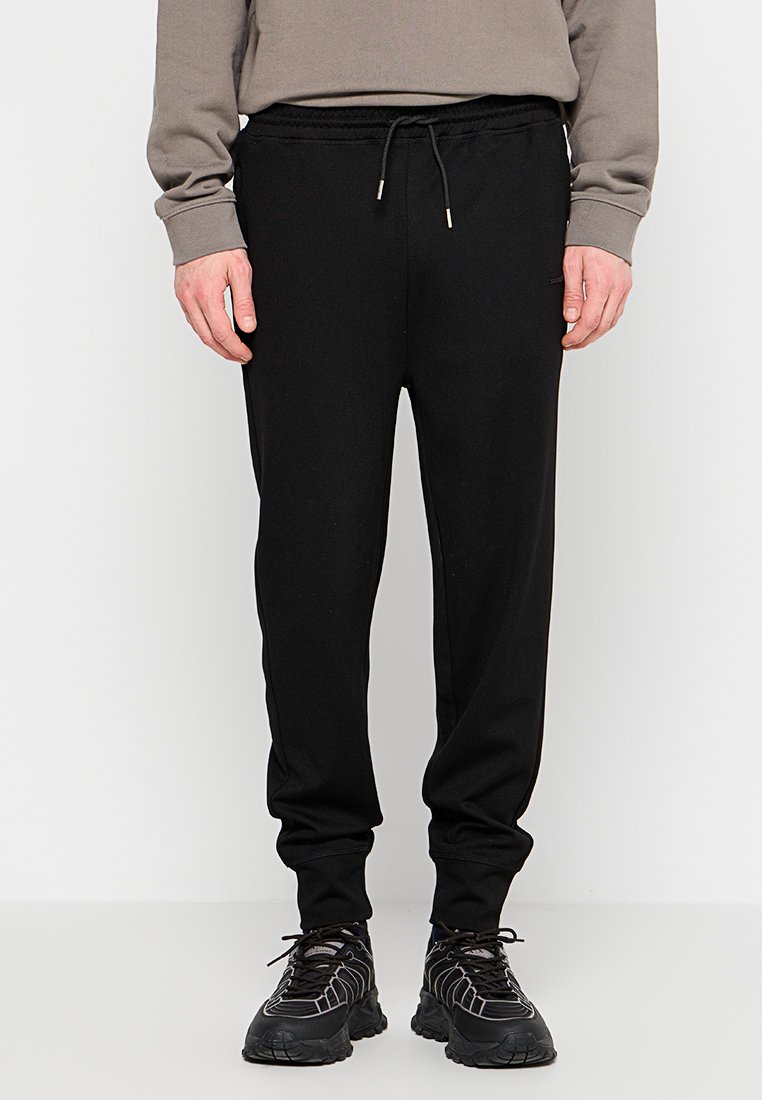 Svarta joggerbyxor i tapered design med elastisk midja och dragsko. Tillverkade av mjukt tyg, med sidofickor.