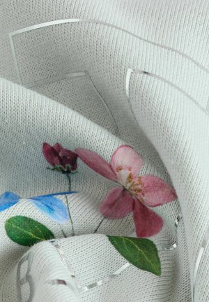 Tessuto lavorato a maglia con una base grigia texture e motivi floreali colorati in rosa, rosso e blu, arricchito da dettagli metallici argentei.