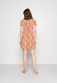 Vestido de manga corta, hasta la rodilla, en un patrón floral de color durazno y naranja, con un corsé ajustado y falda acampanada; tela suave, cuello redondo estándar.