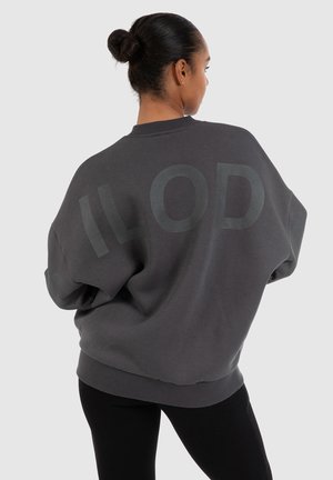 Sweatshirt gris surdimensionné en tissu doux, avec une inscription discrète "ILOD" dans le dos et un col et des poignets côtelés.