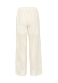 Pantalon blanc à jambes larges brodé avec une taille élastique, présentant des motifs complexes et un tissu texturé sur toute la surface.