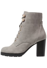 Bottine en daim gris avec fermeture à lacets, œillets dorés, talon bloc robuste et semelle en caoutchouc noire, vue de profil.