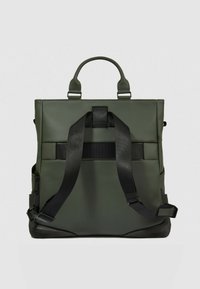 Zaino verde in ecopelle con spallacci neri regolabili, doppia maniglia superiore e base testurizzata. Presenta un design minimalista e strutturato.