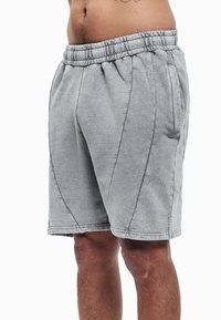Pantalones cortos de mezcla de algodón gris con cintura elástica, dos bolsillos laterales y detalles cosidos para un aspecto deportivo y un ajuste cómodo.