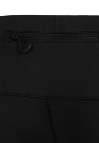 Pantalons de sport noirs avec une poche zippée à l'arrière, fabriqués dans un tissu extensible au toucher lisse et avec des coutures plates.