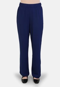 Navyblauwe, losse broek met een elastische tailleband en een gladde textuur, gecombineerd met zwarte flats.