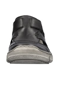 Schwarzer Lederschuh mit strukturiertem Finish, ausgestattet mit elastischen Seitenpaneelen, hellgrauer Sohle und markanter Nahtdetails.