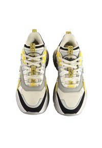 Športni čevlji v beli mrežasti tkanini z sivo, črno in rumenimi poudarki. Imajo vezalke, logotipe in strukturo podplata za boljši oprijem.