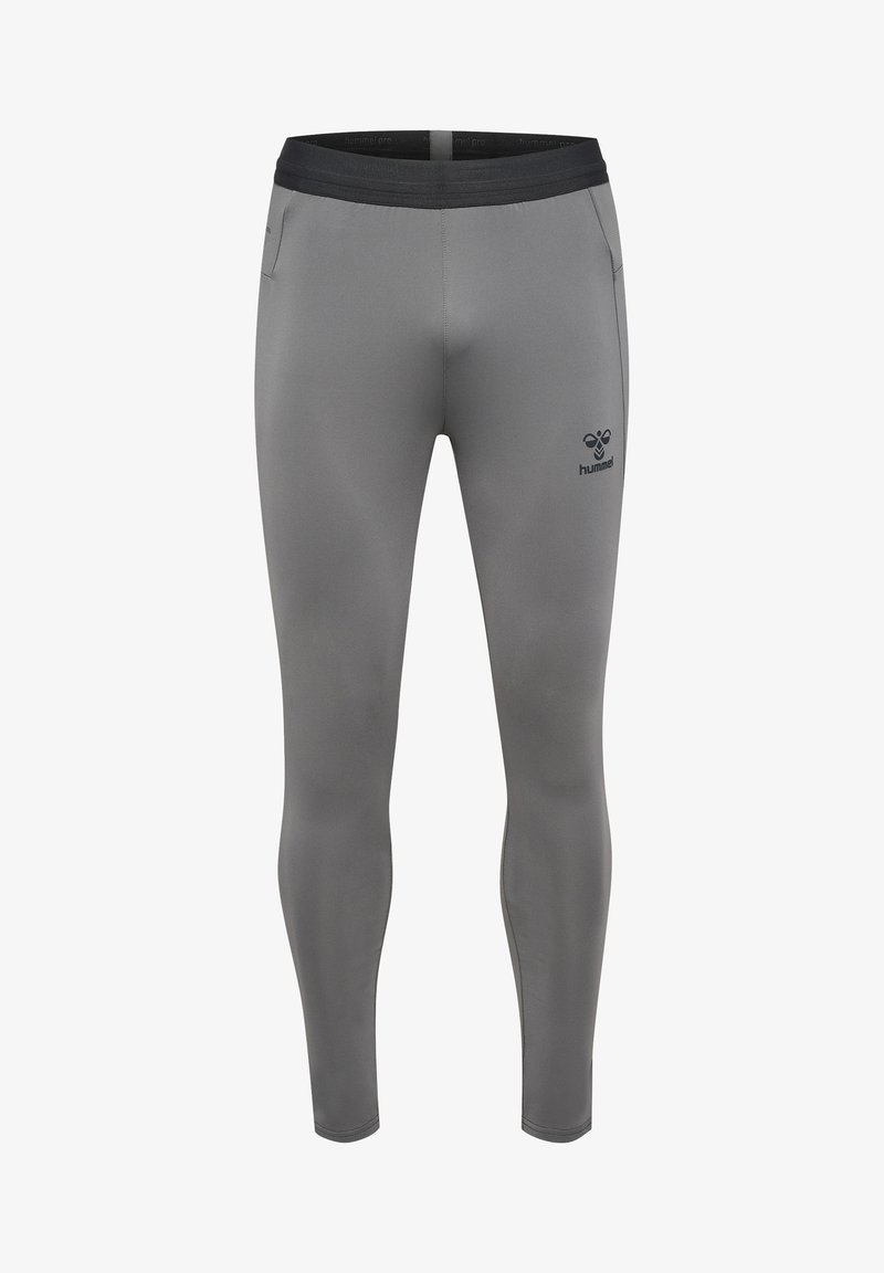 Leggings de sport ajustés gris avec une ceinture noire, des poches latérales et un petit logo sur la cuisse gauche, fabriqués en matériau lisse et extensible.