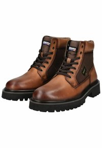 Bottines en cuir marron avec une finition texturée, bout rond et semelle en caoutchouc noir à crampons. Présente des accents en tissu marron et des lacets noirs.