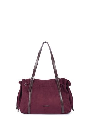 Sac à main en daim rouge foncé avec des anses en cuir marron foncé plus longues, détails cordon sur le côté et logo argenté "Lancaster" au centre devant.