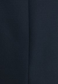 Tela de un navy oscuro con un patrón geométrico texturizado de pequeños diamantes, que presenta un acabado suave y un ligero brillo.