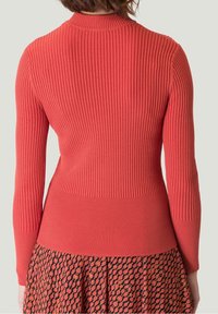 Pull coral à manches longues côtelé avec un design ajusté et un col rond. La vue de dos met en avant des détails texturés et une construction sans couture.