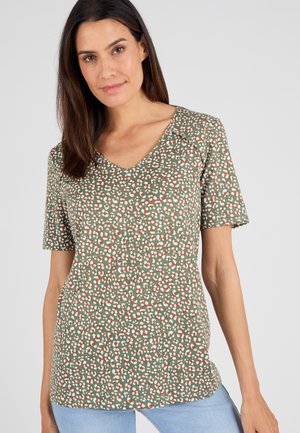 Camisa de manga corta y escote en V de tela verde con un patrón variado de manchas blancas y naranjas. Corte sencillo y relajado con una textura suave.