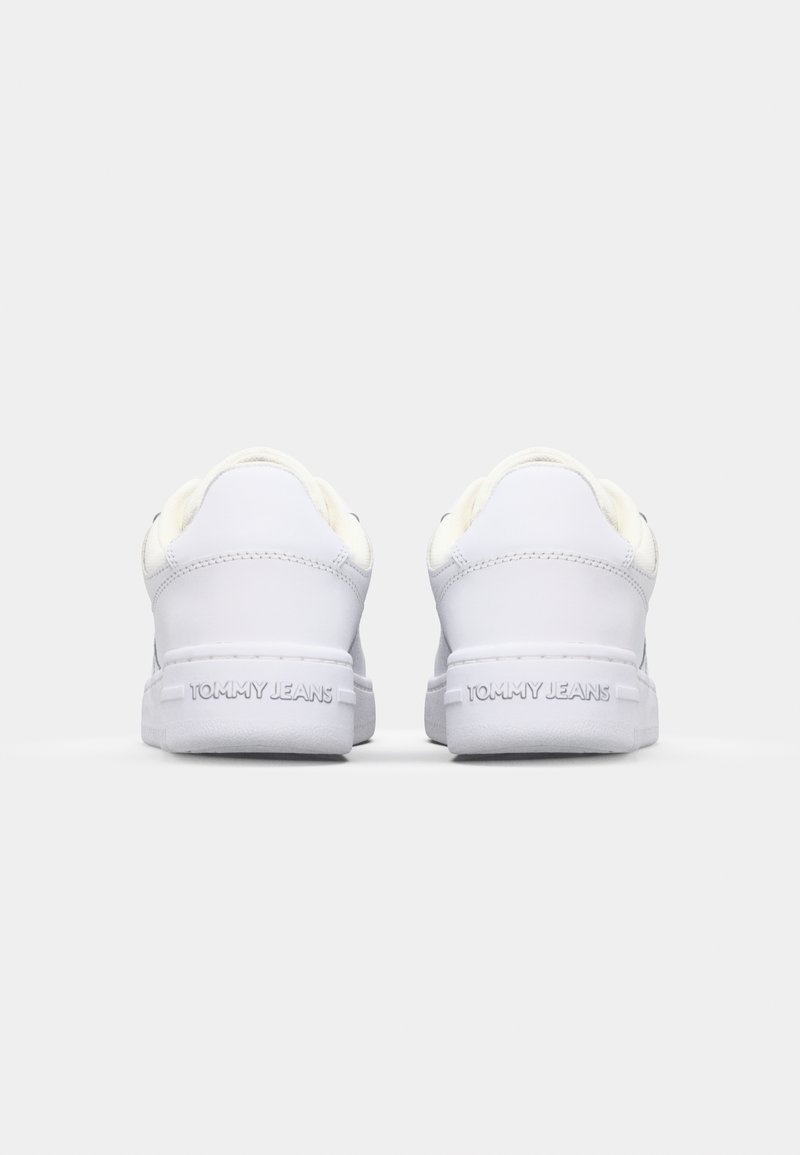 Sneakers bianchi in pelle con design a scarpa bassa, dotati di una suola in gomma testurizzata e il marchio "TOMMY JEANS" sul tallone.