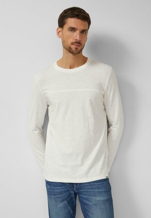 Koszulka z długim rękawem i okrągłym dekoltem w kolorze kremowym, wykonana z miękkiego materiału z teksturowanym poziomym paskiem na wysokości klatki piersiowej.