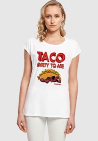 Hvid bomulds T-shirt med grafisk tryk med teksten "TACO DIRTY TO ME" og en illustration af Deadpool på en taco-baggrund. Casual fit, kortærmet.