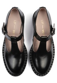 Chaussures en cuir noir avec bride à la cheville, bout fermé et design ajouré. Semelle plateforme texturée et doublure intérieure lisse.