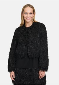 Schwarze, taillierte Jacke aus strukturiertem, fransigem Material mit metallischen Fäden. Verfügt über lange Ärmel und einen runden Halsausschnitt.