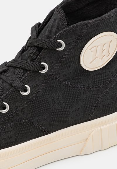 Adidași negri până la gleznă, din material texturat, cu talpă din cauciuc, accente crem și plăcuță de marcă. Prezintă orificii rotunde pentru șireturi și șireturi plate.