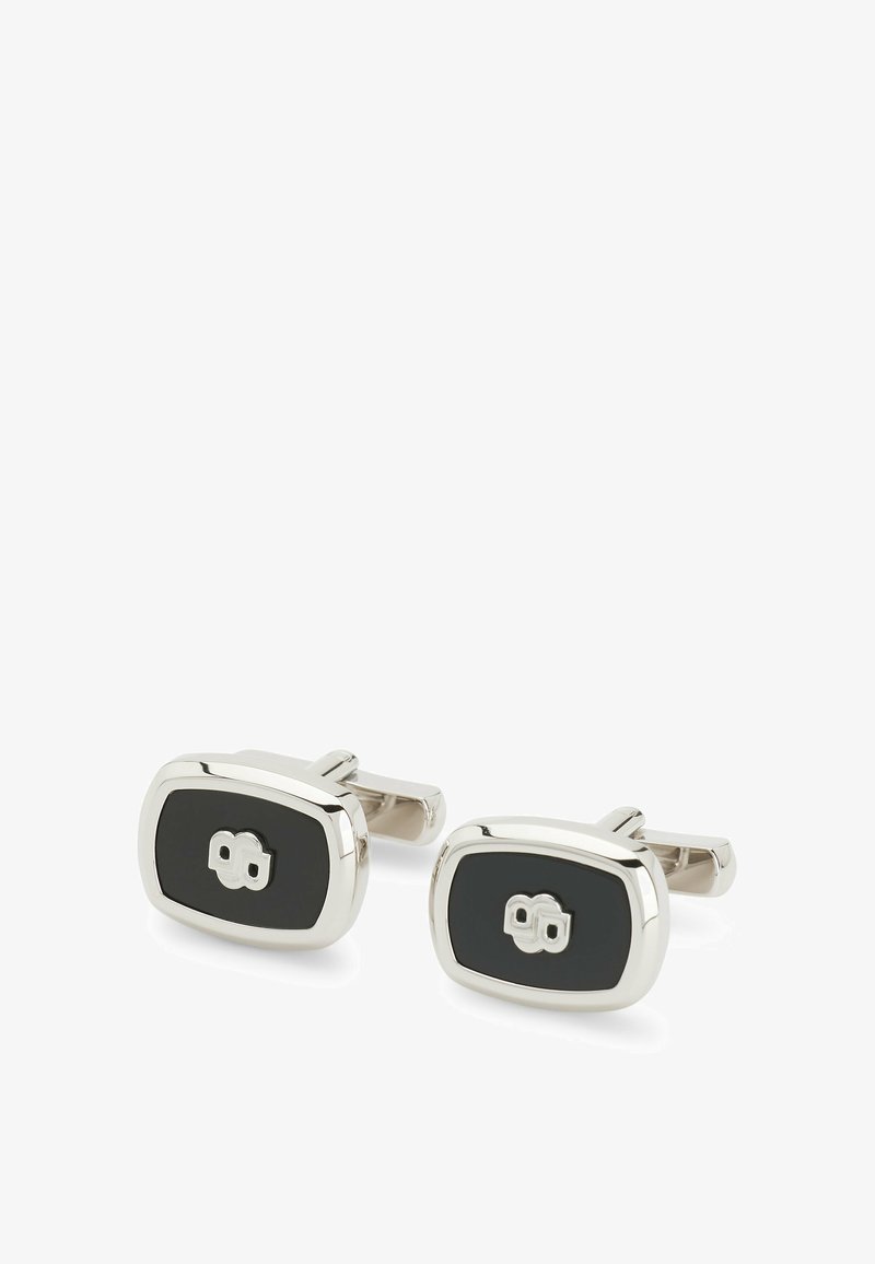 Silver and black cufflinks with an oval shape, featuring a glossy silver frame and a central black inlay, accented by a distinct emblem.
