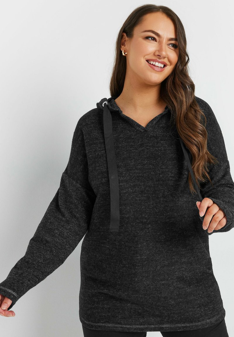 Tummanharmaa huppari, jossa on tekstuuri pinta, v-henkinen kaula-aukko ja nauhavedot. Pitkät hihat ja rentouttava olkapäiden pudotus lisäävät mukavuutta.