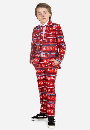 Rød julesuite med mønster designet med snefnug og rensdyr, parret med en hvid skjorte og sorte sneakers.