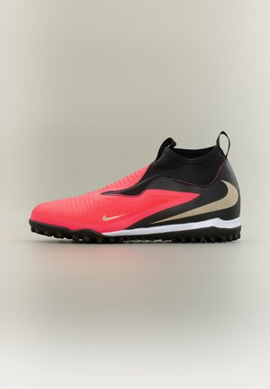 Κόκκινο και μαύρο ποδοσφαιρικό παπούτσι με χρυσό σύμβολο Nike, μαύρη σόλα με μικρά καρφιά, μεσαίο ύψος και θηλιά στη φτέρνα σε μονόχρωμο φόντο.