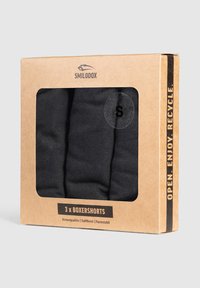 Zwarte boxershortset, drie stuks zichtbaar door een transparant venster, gepresenteerd in een bruine kartonnen doos met zwarte tekst en logo.