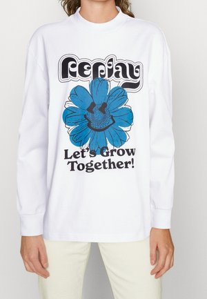 White long-sleeve t-shirt featuring a blue flower graphic with a smiley face and the text "Let's Grow Together!" in bold black font.