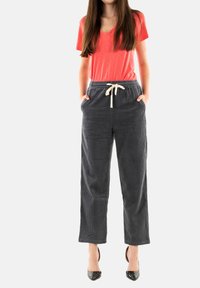 Camisa de algodón de mezcla con escote en V en color coral, combinada con pantalones de pana gris carbón con puños, que cuentan con una cintura con cordón y bolsillos laterales.