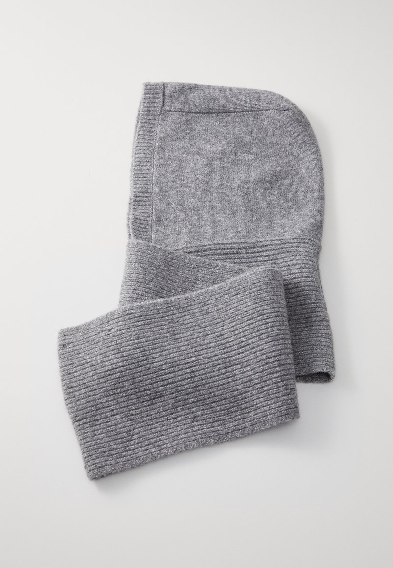 Passamontagna en maille grise avec texture côtelée autour du cou et de l'ouverture du visage, posé à plat sur une surface blanche.