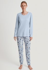 Lichtblauwe pyjama-top met lange mouwen en een ronde hals; bijpassende lichtblauwe broek met verschillende dierenprints in donkerblauw en grijs.