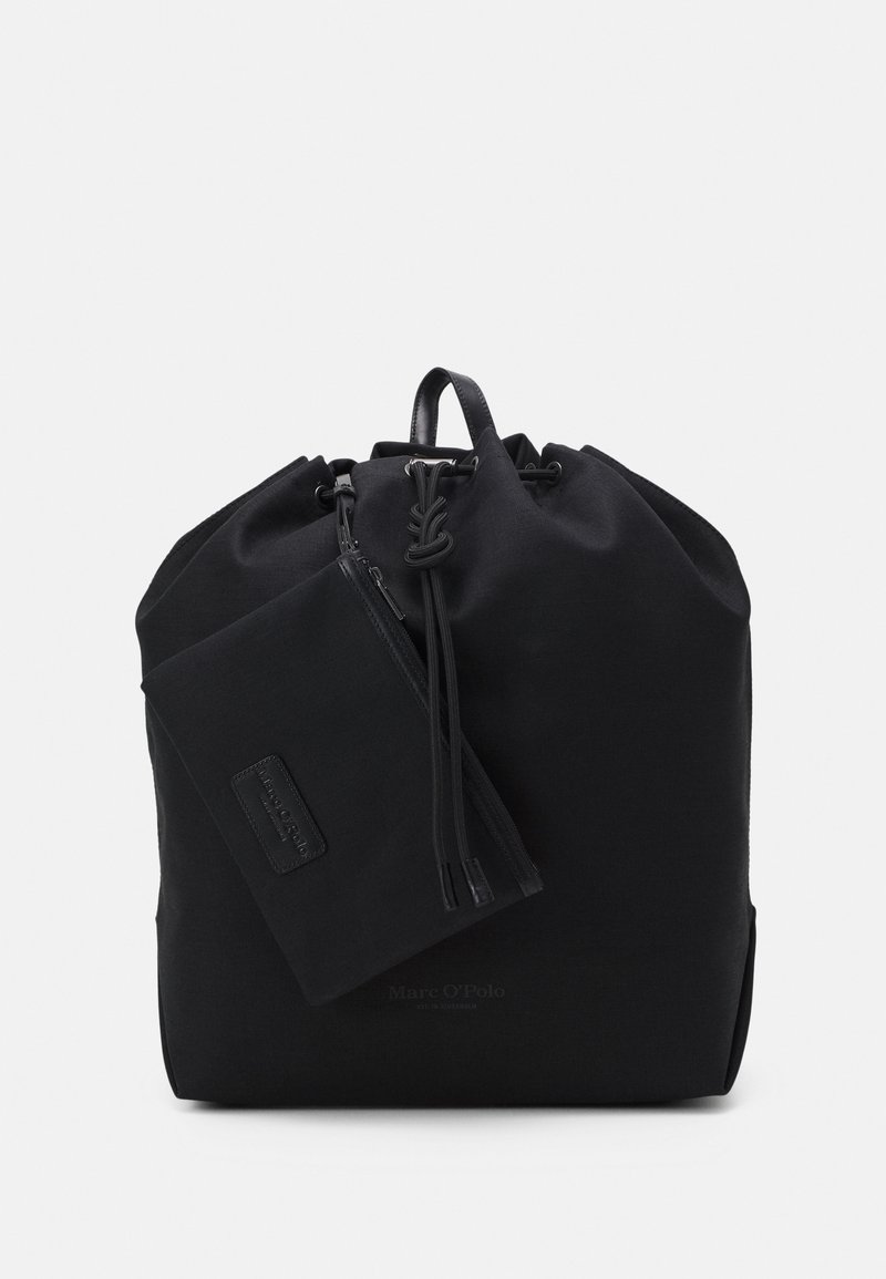 Sac à dos en tissu noir avec un haut resserré, des accents en cuir et une pochette zippée détachable. Présente un design minimaliste et une texture lisse.