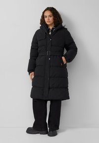 Crna puffer jakna s remenom u struku, visokim kragnom i kopčanjem na dugmadi. Ima bočne džepove i glatku, blago sjajnu teksturu.