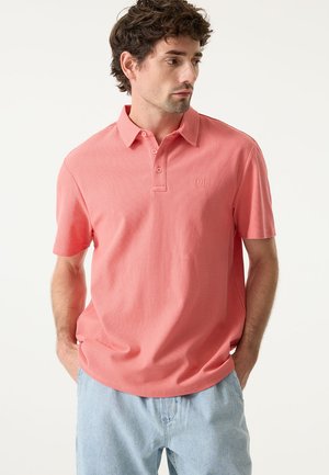 Polo met korte mouwen in koraal, met een gestructureerde stof, kraag en een drieknopsbies. Geborduurd logo op de borst.