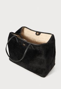 Sort tote bag med blød, struktureret overflade, læderdetaljer og dobbelte håndtag. Indvendigt har den en lys beige foret med et logo-mønster.