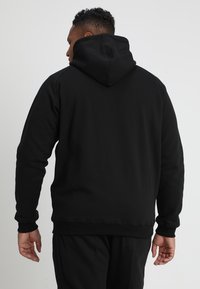 Black sweatshirt with a hood, ribbed cuffs and hem. Soft texture, simple design, and a relaxed fit, focusing on comfort and warmth.
