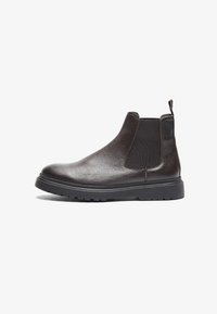 Bottines Chelsea en cuir marron avec panneaux élastiques sur les côtés, une languette de tirage et une finition texturée. Bout rond et semelle en caoutchouc.