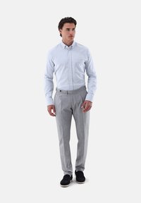 Hellblau und weiß kariertes Button-up-Hemd kombiniert mit maßgeschneiderten grauen Hosen. Das Outfit zeichnet sich durch eine glatte Textur und einen körpernahen Schnitt aus.