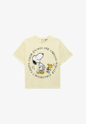 Camiseta color crema con Snoopy y Woodstock bailando, rodeados por el texto "Vienen cosas buenas" y "Snoopy & Woodstock Est. 1950".