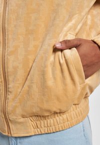 Karl Kani CHEST SIGNATURE MONOGRAM VELVET - Sportinė striukė - sand